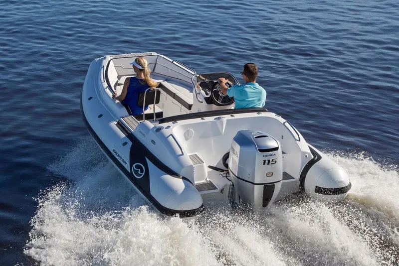 Slide: The Image of Manufacturer Provided Image: 2025 Walker Bay Generation 525 DLX boat cruising on open water. - 2
