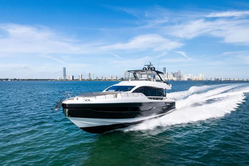 Slide: The Image of 2021 Azimut Fly 78 yacht cruising on blue ocean with city skyline backdrop. - 5