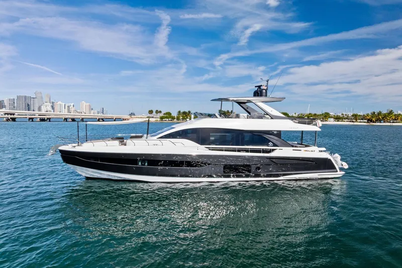 Slide: The Image of 2021 Azimut Fly 78 yacht cruising near a city skyline under a clear blue sky. - 8