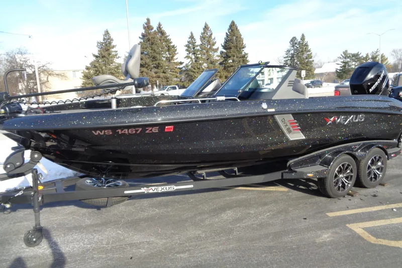 Slide: The Image of 2022 Vexus DVX 22 boat on trailer, black with metallic finish, parked outdoors. - 13