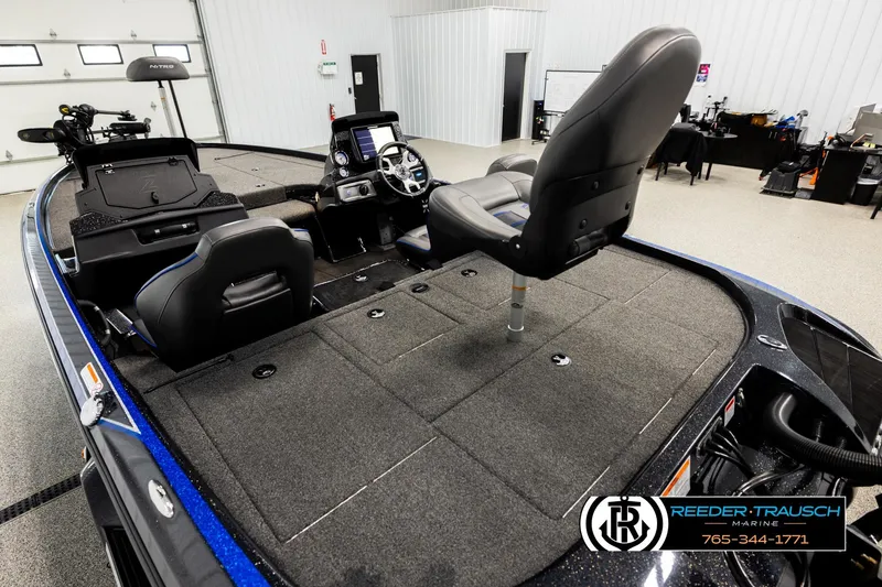 Slide: The Image of 2024 Bass Tracker Nitro Z20 boat interior with seating and control console in showroom. - 10