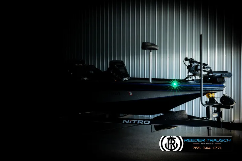 Slide: The Image of 2024 Bass Tracker NitroZ20 boat in dimly lit garage, side view. - 3