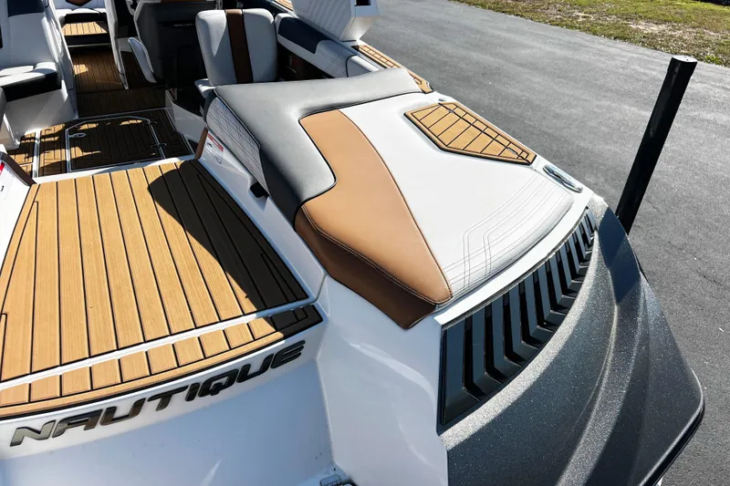 Slide: The Image of 2019 Nautique Super Air Nautique G23 boat interior with teak flooring and cushioned seating. - 7