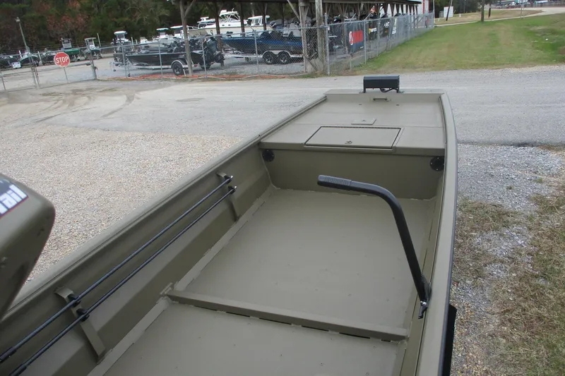 Slide: The Image of 2026 Gator Tail 1748 GATOR boat, empty interior view, parked near a fence. - 3