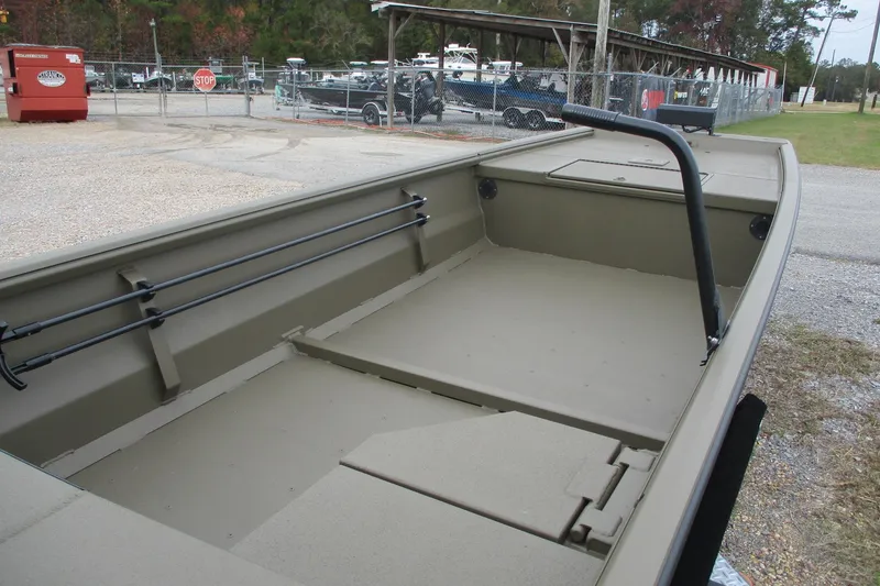 Slide: The Image of 2026 Gator Tail 1748 GATOR boat, empty interior, parked outdoors near a fence. - 4