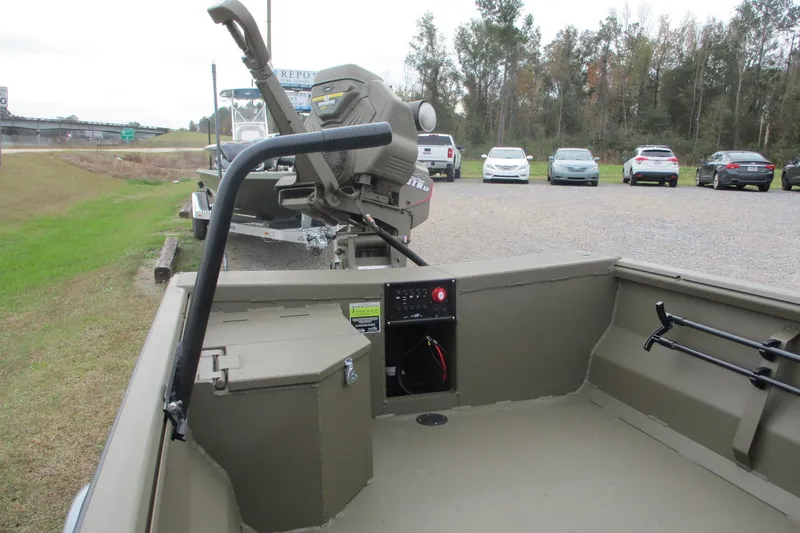 Slide: The Image of 2026 Gator Tail 1748 GATOR boat interior with motor, parked near grassy area. - 5