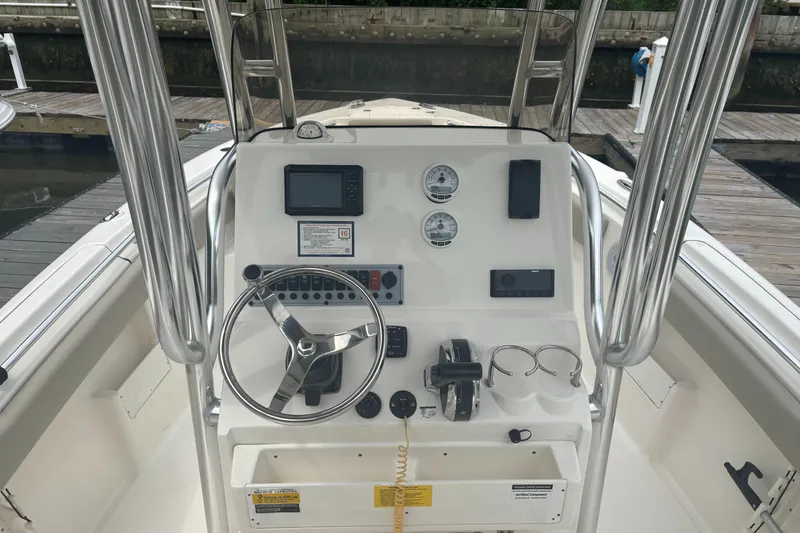 Slide: The Image of 2024 Key West 239 FS boat console with steering wheel, gauges, and controls at dock. - 5