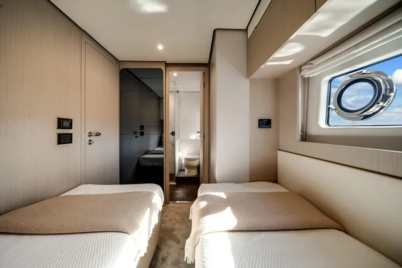 Slide: The Image of Luxurious cabin interior of 2023 Azimut Fly 68 yacht with twin beds and porthole window. - 25