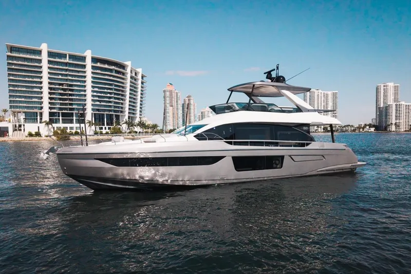 Slide: The Image of 2023 Azimut Fly 68 yacht cruising near modern waterfront buildings. - 52