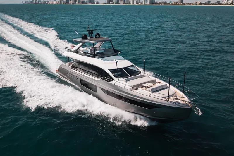 Slide: The Image of 2023 Azimut Fly 68 yacht cruising on open water, city skyline in background. - 56