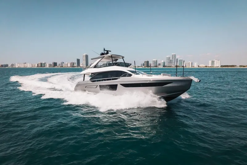 Slide: The Image of 2023 Azimut Fly 68 yacht cruising on ocean with city skyline in background. - 64