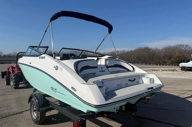 Slide: The Image of 2026 Yamaha Boats SX195 on trailer, featuring sleek design and bimini top. - 6