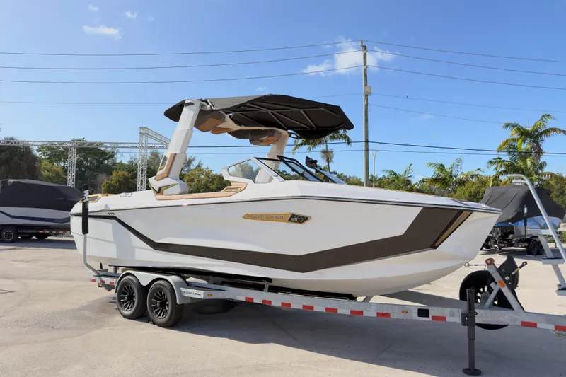 Slide: The Image of 2025 Nautique Super Air Nautique G25 Paragon boat on trailer, sunny day, palm trees background. - 14