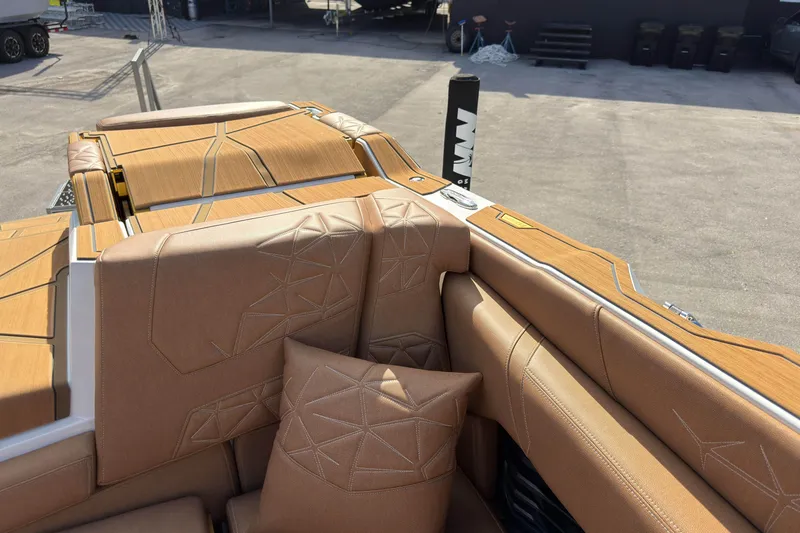 Slide: The Image of 2025 Nautique Super Air Nautique G25 Paragon interior with tan upholstery and geometric stitching. - 19