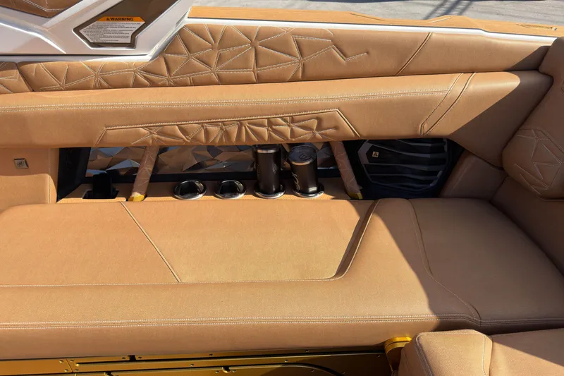 Slide: The Image of Luxurious interior of 2025 Nautique Super Air Nautique G25 Paragon with tan upholstery and cup holders. - 21