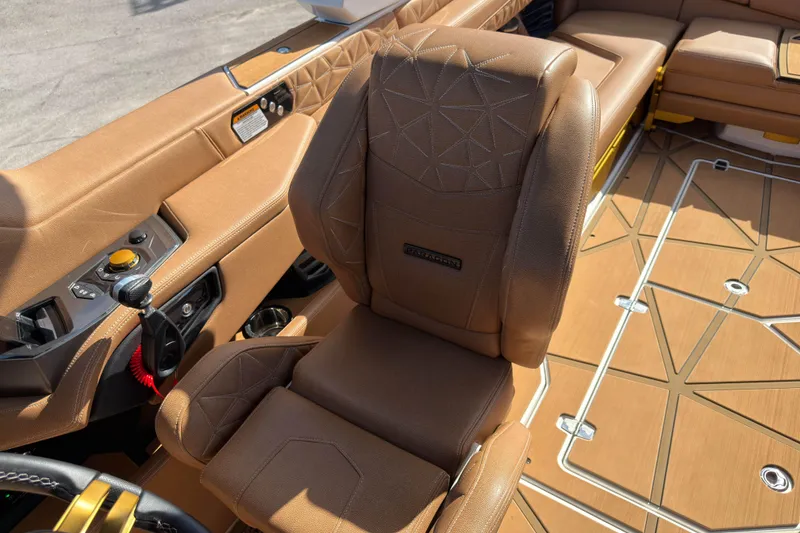 Slide: The Image of 2025 Nautique Super Air Nautique G25 Paragon interior with luxurious brown seating and controls. - 25