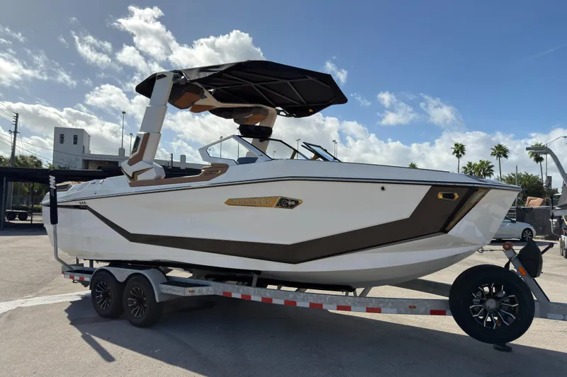 Slide: The Image of 2025 Nautique Super Air Nautique G25 Paragon boat on trailer under blue sky. - 7