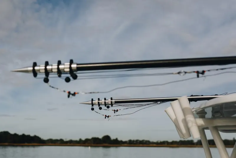 Slide: The Image of Outriggers on a 2023 Yellowfin 32 Offshore boat against a cloudy sky. - 15