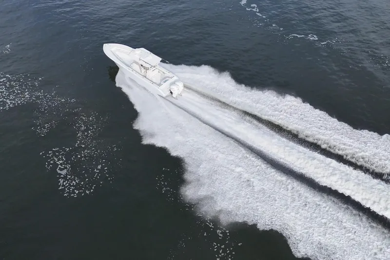 Slide: The Image of Aerial view of 2023 Yellowfin 32 Offshore boat speeding on water. - 2