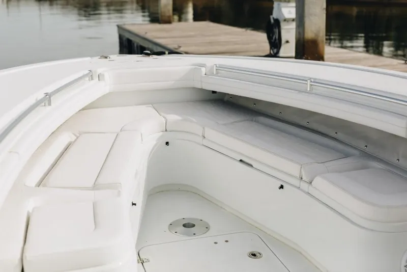 Slide: The Image of 2023 Yellowfin 32 Offshore boat interior with white cushioned seating near dock. - 21