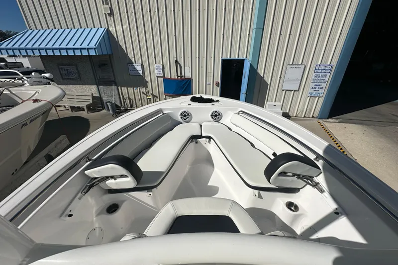 Slide: The Image of 2025 Tidewater 198 CC Adventure boat interior with white seating, docked near a building. - 10