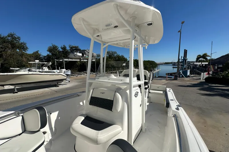 Slide: The Image of 2025 Tidewater 198 CC Adventure boat docked under clear blue sky. - 14