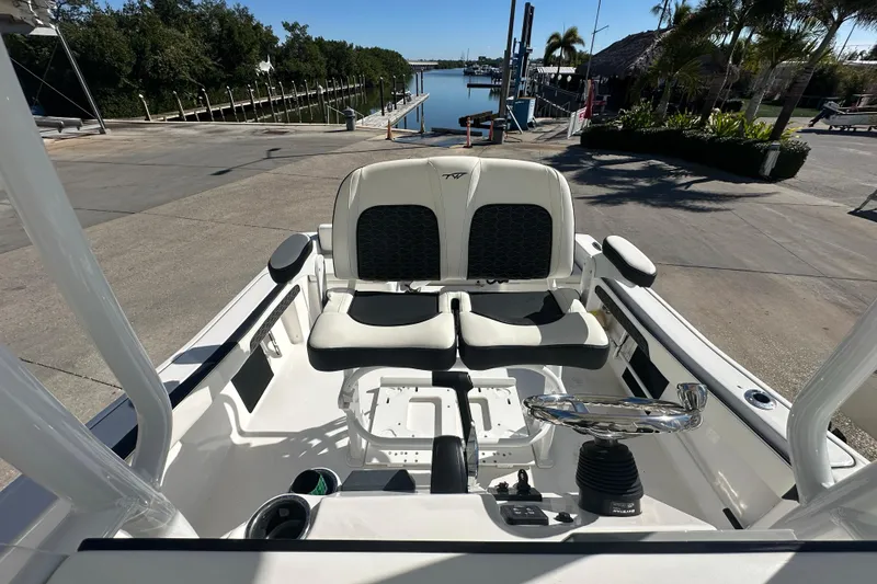 Slide: The Image of 2025 Tidewater 198 CC Adventure boat interior with dual seats and steering wheel at dock. - 19