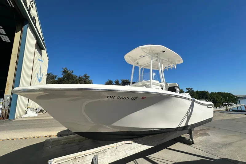 Slide: The Image of 2025 Tidewater 198 CC Adventure boat on a dock under clear blue sky. - 7