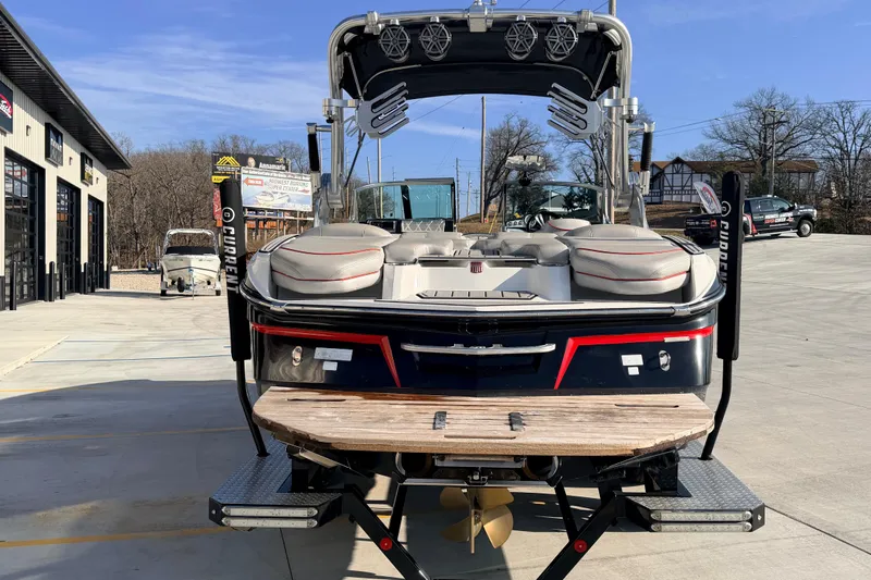 Slide: The Image of 2015 MasterCraft X20 boat, rear view, parked outdoors on a sunny day. - 2