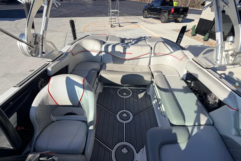 Slide: The Image of 2015 MasterCraft X20 boat interior with gray seating and red accents. - 30