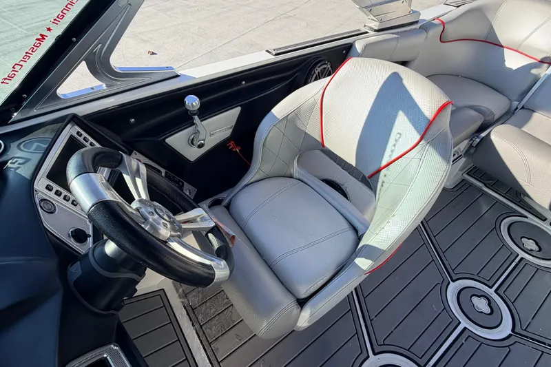 Slide: The Image of 2015 MasterCraft X20 boat interior with steering wheel and gray seating. - 38