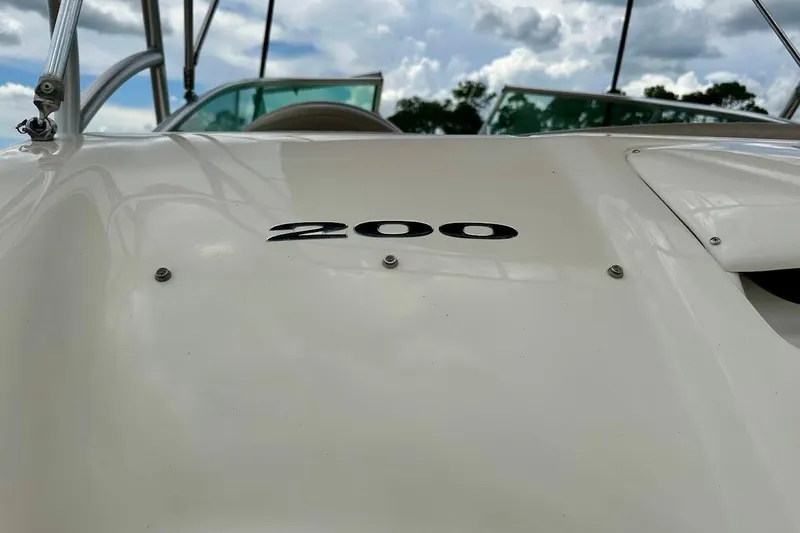 Slide: The Image of Close-up of 2004 Sea Ray 200 Sundeck boat with "200" emblem, under cloudy sky. - 14