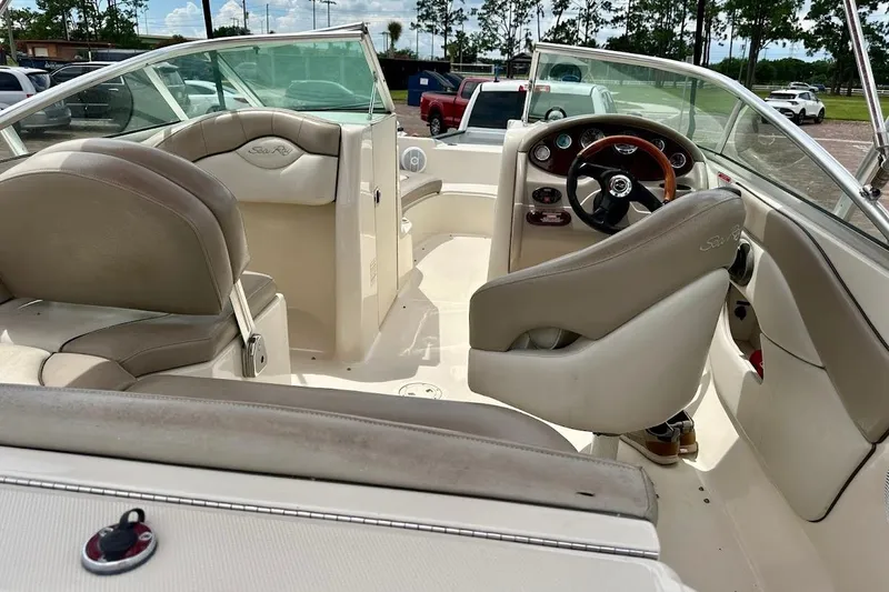 Slide: The Image of 2004 Sea Ray 200 Sundeck interior with beige seating and steering wheel. - 17
