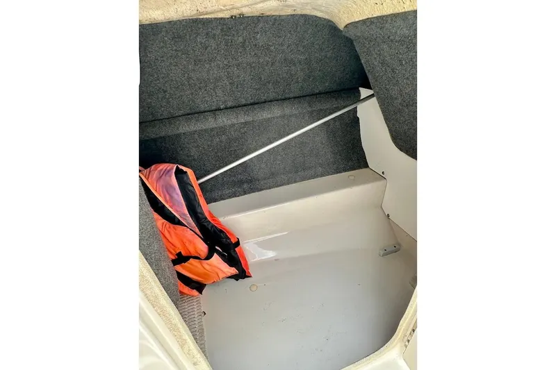 Slide: The Image of Interior storage compartment of 2004 Sea Ray 200 Sundeck with life jacket. - 24