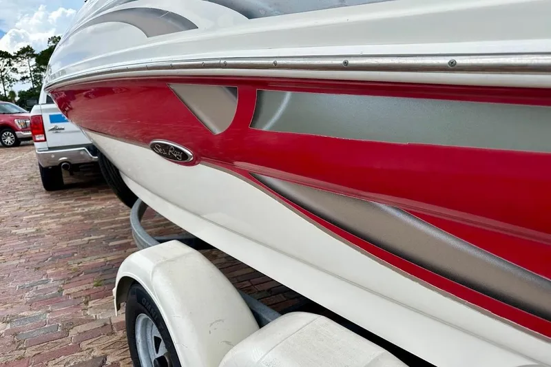 Slide: The Image of 2004 Sea Ray 200 Sundeck boat on trailer, featuring red and white design. - 3
