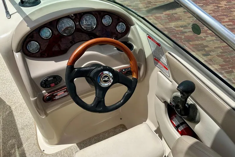 Slide: The Image of 2004 Sea Ray 200 Sundeck dashboard with steering wheel and control panel. - 30