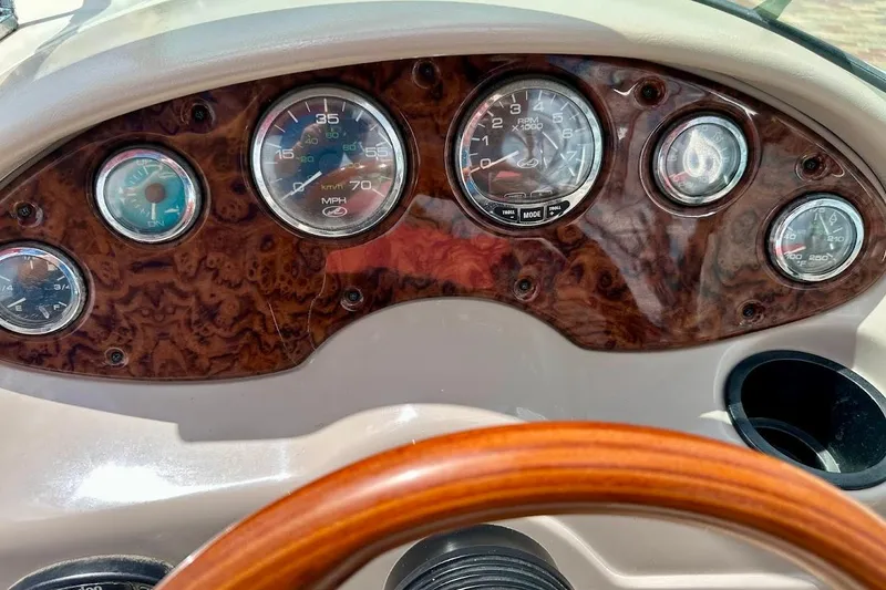 Slide: The Image of Dashboard of a 2004 Sea Ray 200 Sundeck boat with wood grain finish and gauges. - 33