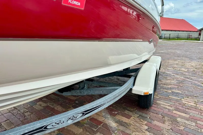 Slide: The Image of Red and white 2004 Sea Ray 200 Sundeck boat on trailer, parked on brick pavement. - 5