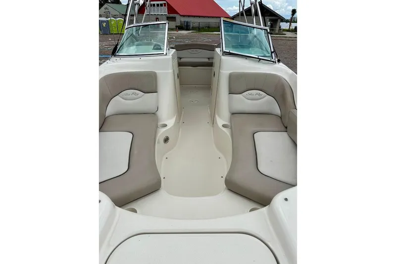 Slide: The Image of 2004 Sea Ray 200 Sundeck interior with beige seating and open deck layout. - 8
