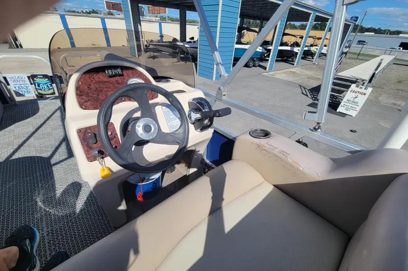 Slide: The Image of 2015 Sun Tracker Party Barge 16 DLX interior with steering wheel and seating area. - 10