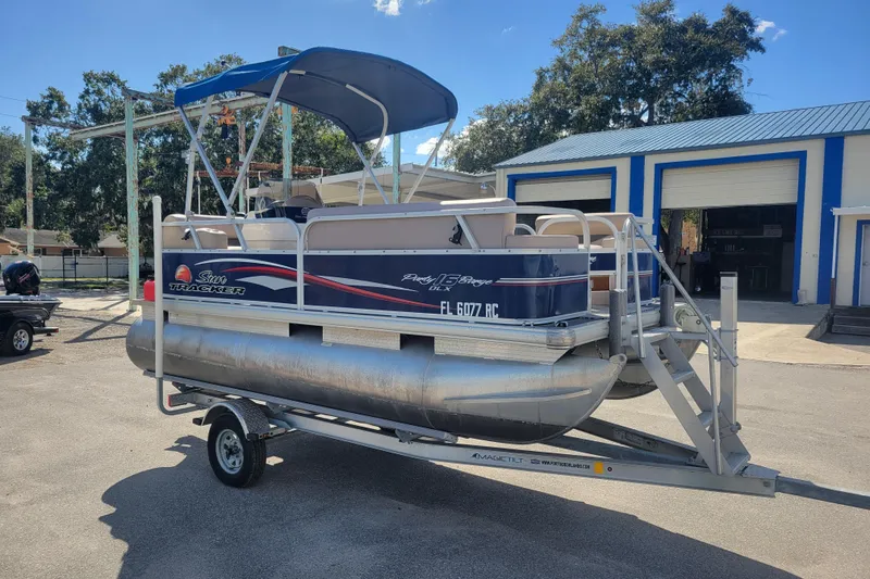 Slide: The Image of 2015 Sun Tracker Party Barge 16 DLX pontoon boat on trailer, parked outdoors. - 3