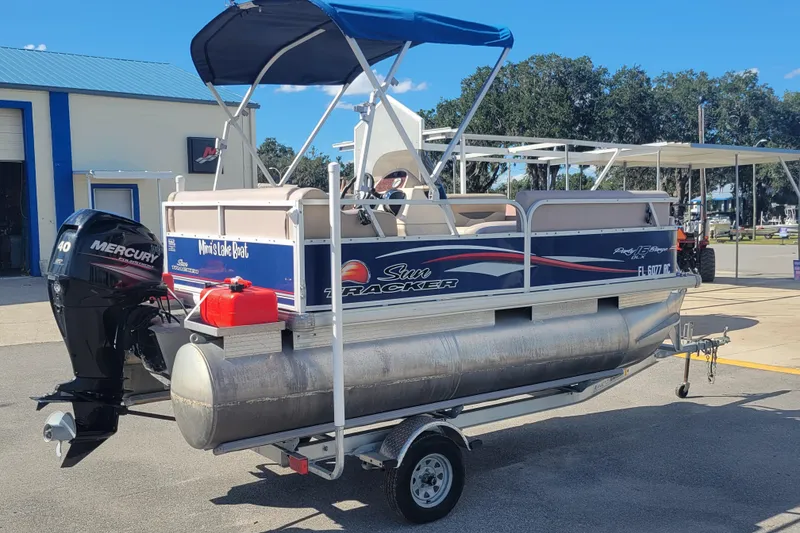 Slide: The Image of 2015 Sun Tracker Party Barge 16 DLX pontoon boat on trailer, with Mercury outboard motor. - 4