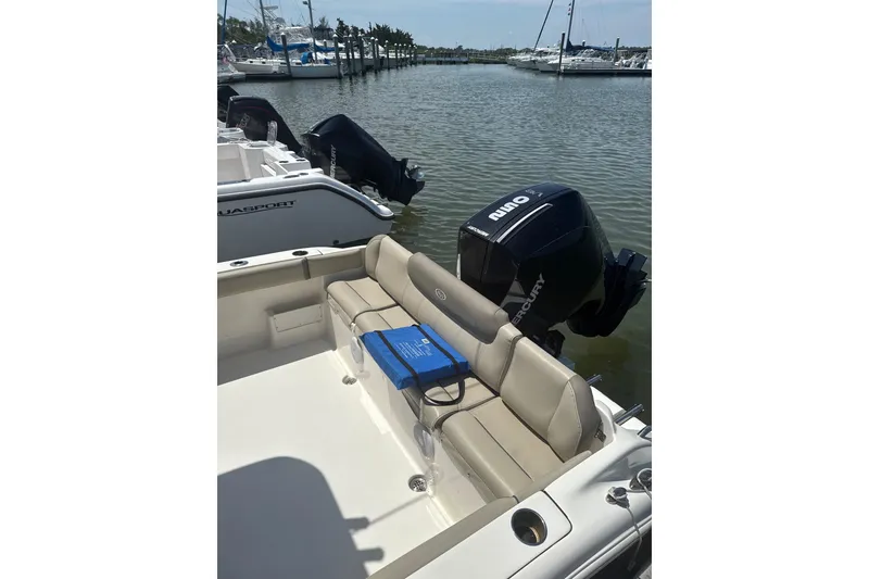 Slide: The Image of 2024 Key West 239 FS boat with beige seating and Mercury outboard engine at marina. - 10