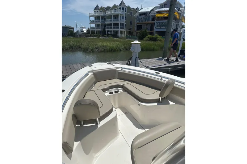 Slide: The Image of 2024 Key West 239 FS boat interior with seating, docked near waterfront homes. - 5