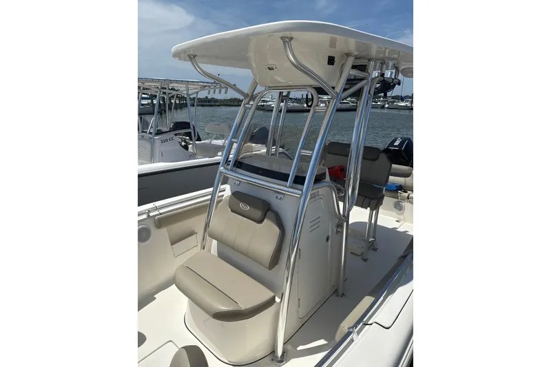 Slide: The Image of 2024 Key West 239 FS boat interior with seating and T-top, docked by the water. - 6