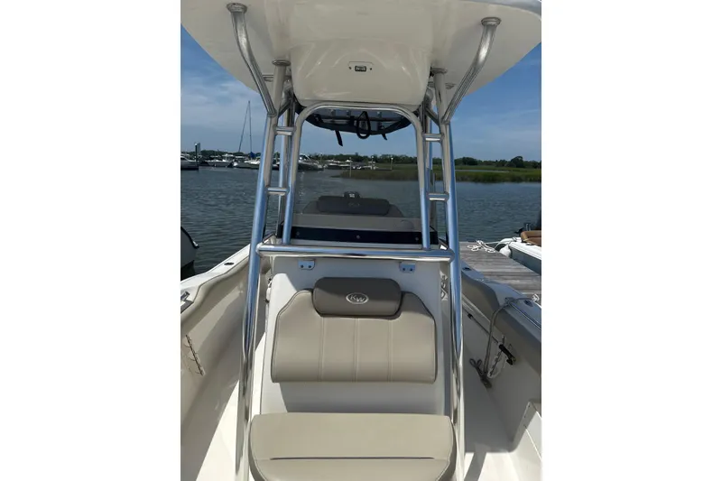 Slide: The Image of 2024 Key West 239 FS boat interior with seating and console, docked by the water. - 7