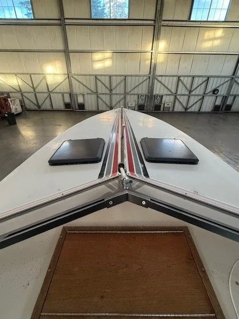 Slide: The Image of Bow view of a 1983 Mirage 314 SZ boat in a warehouse. - 2