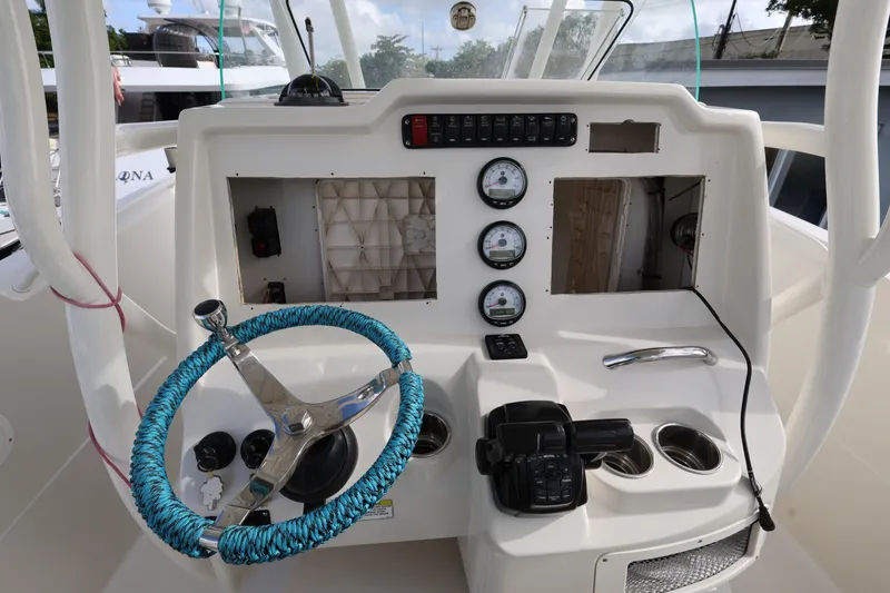 Slide: The Image of 2014 Sailfish 270 CC boat dashboard with blue-wrapped steering wheel and instrument panel. - 11
