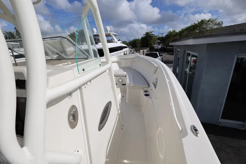 Slide: The Image of 2014 Sailfish 270 CC boat deck with seating, under a partly cloudy sky. - 13