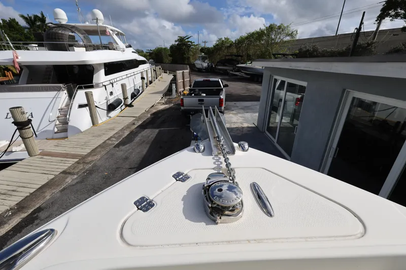 Slide: The Image of Bow view of 2014 Sailfish 270 CC boat docked near a large yacht. - 15